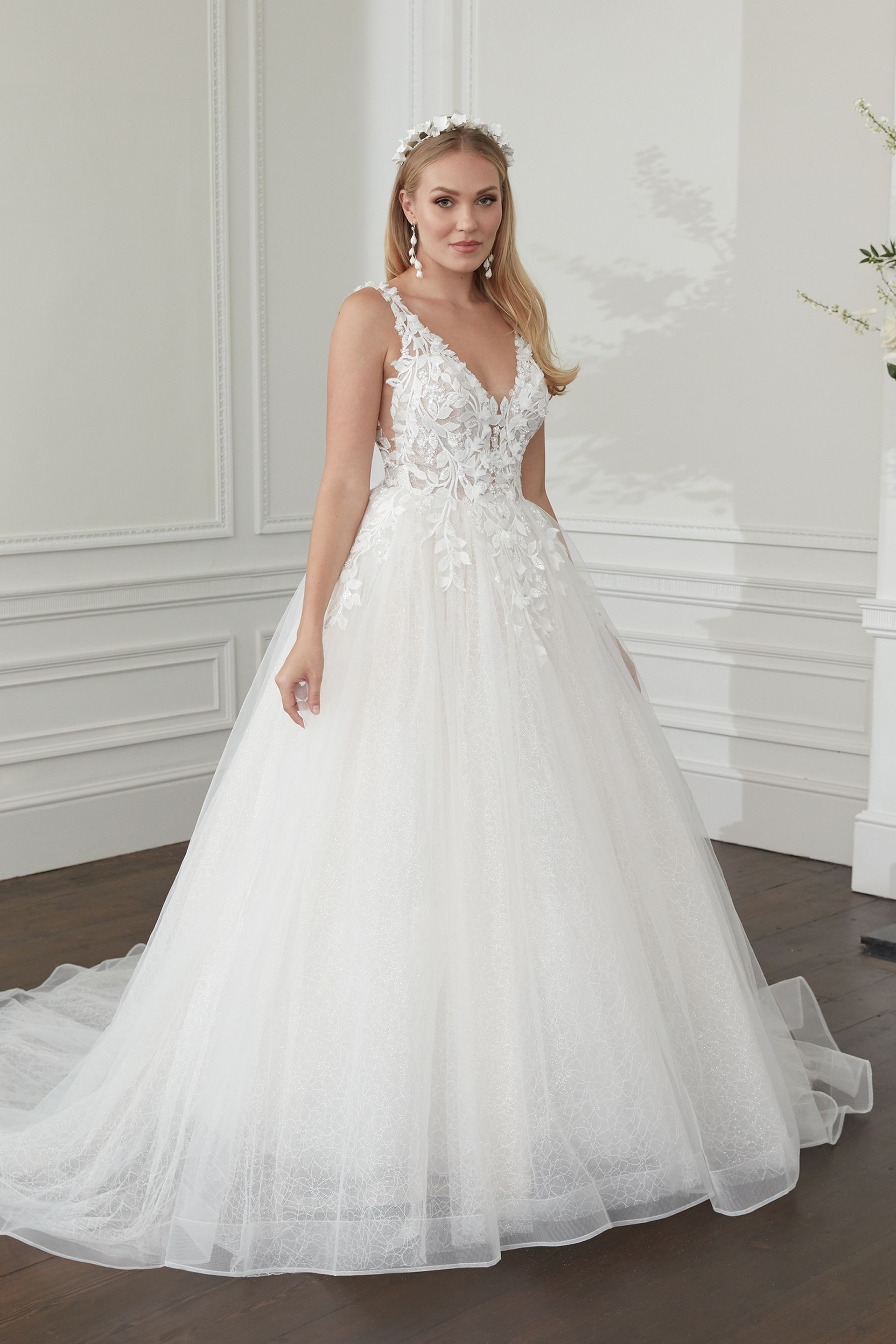 Eine Frau in einem weißen Brautkleid steht in einem Raum.
