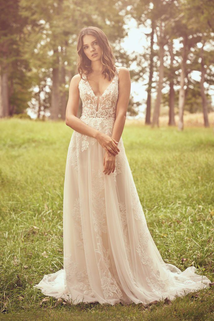 Eine Frau in einem Brautkleid steht auf einem Feld.