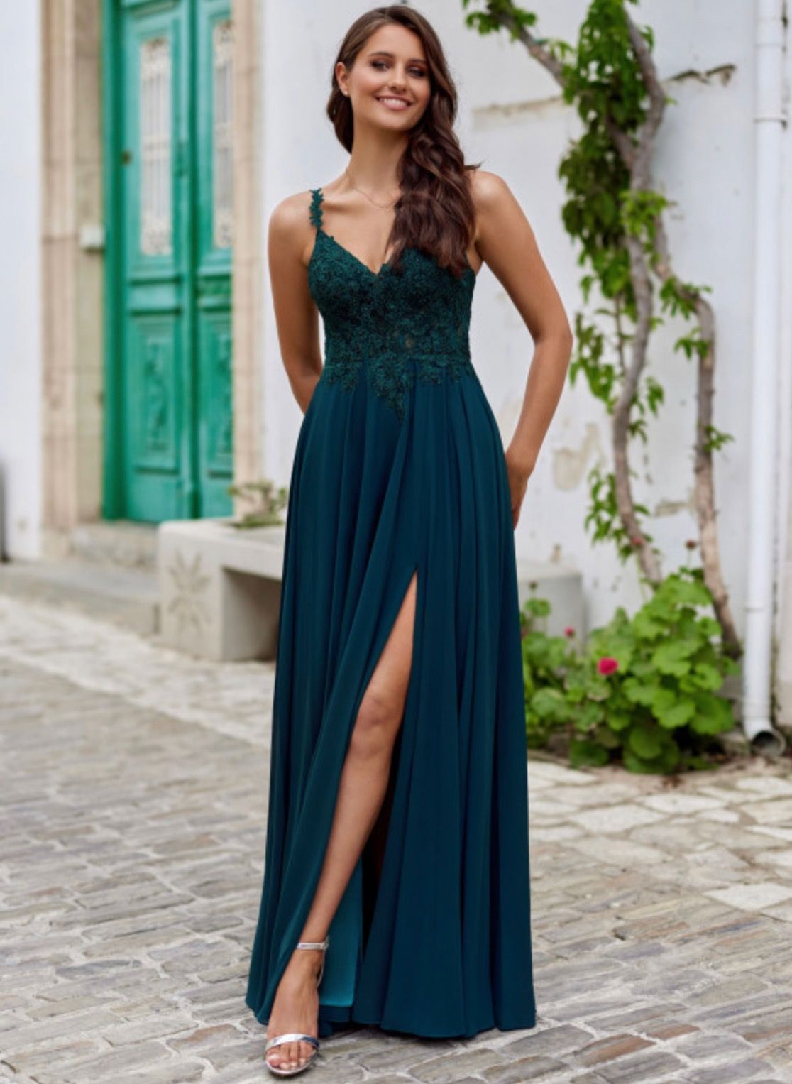 Eine Frau trägt ein langes grünes Kleid mit hohem Schlitz.