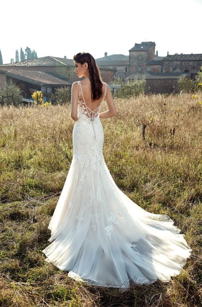 Eine Frau in einem Brautkleid steht auf einem Feld.