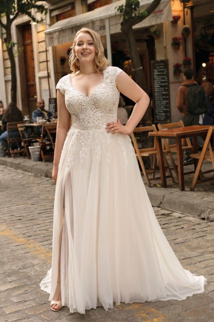 Eine Frau in einem Brautkleid steht auf einem Bürgersteig vor einem Restaurant.