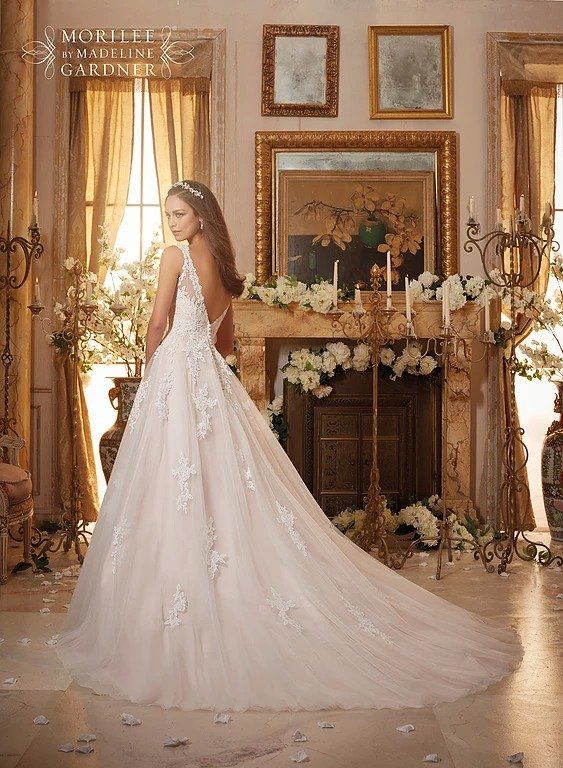 Eine Frau in einem Brautkleid steht in einem Zimmer vor einem Kamin.