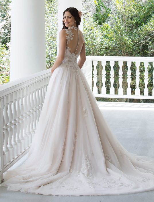 Eine Frau in einem Brautkleid steht auf einer Veranda.