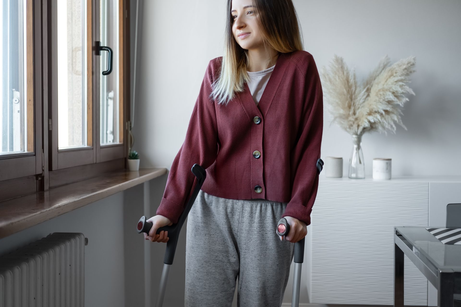 woman in the red sweater walks with crutches, she knows how disability insurance work