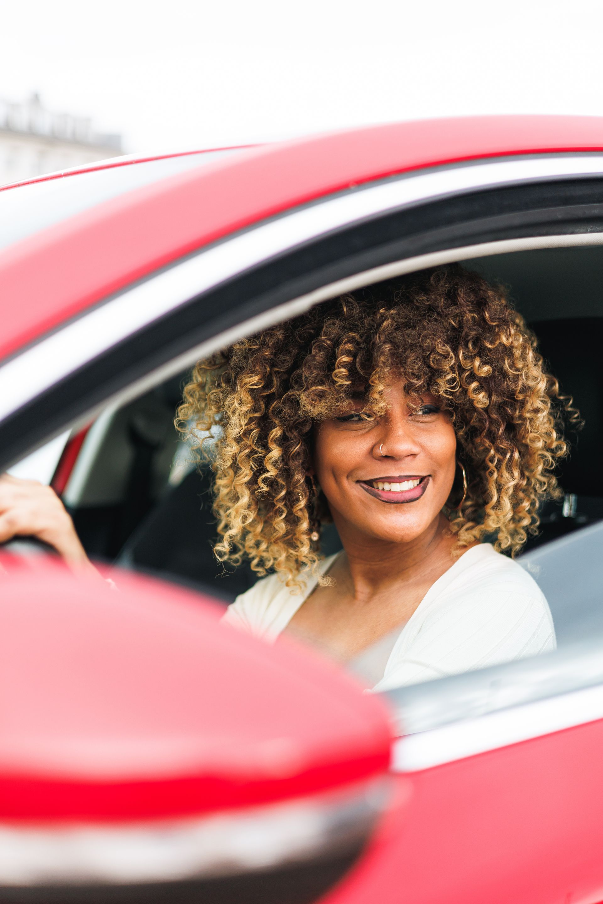 A smiling woman driving a fleet vehicle fully insured