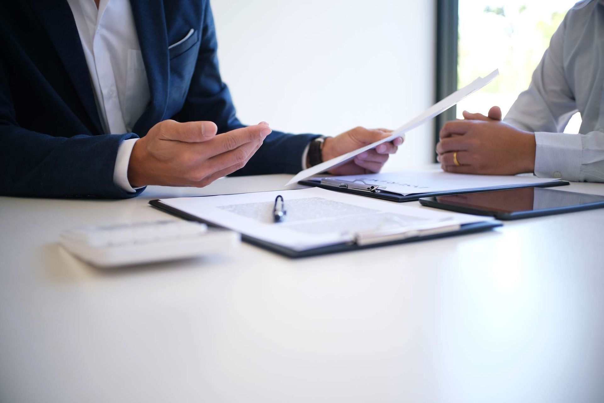 A A professional wearing a suit discusses a contract with a client.