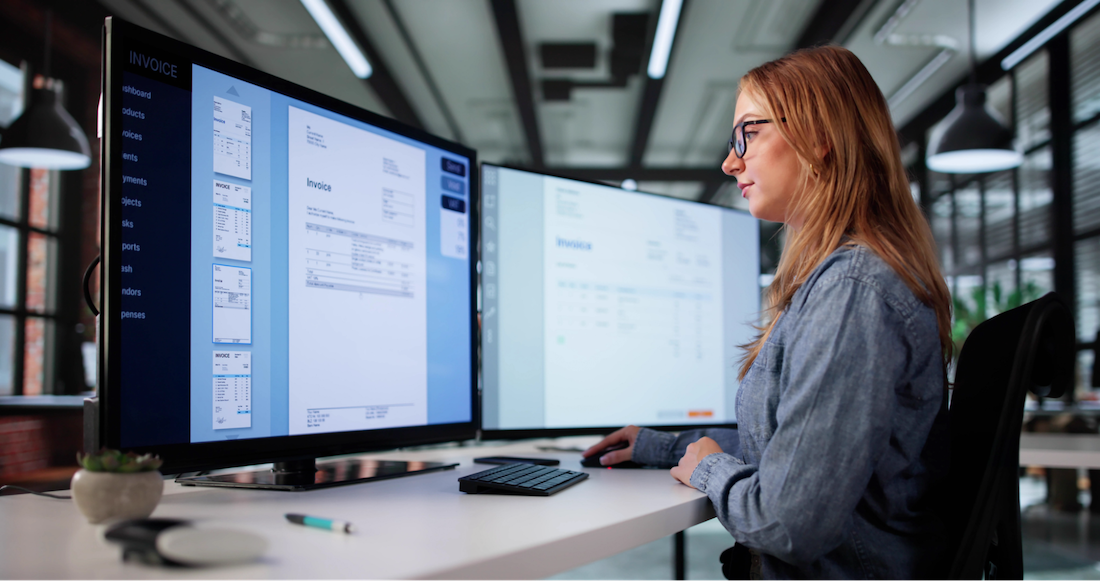 Woman sitting at computer viewing invoices