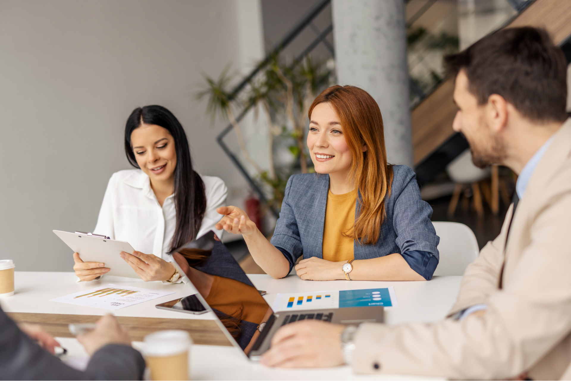 Woman speaking to agroup of people sitting around a conference room table