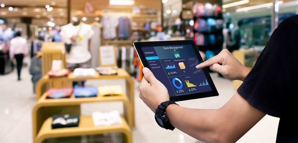 man using a ipad to look at his store metrics to lower his business insurance.
