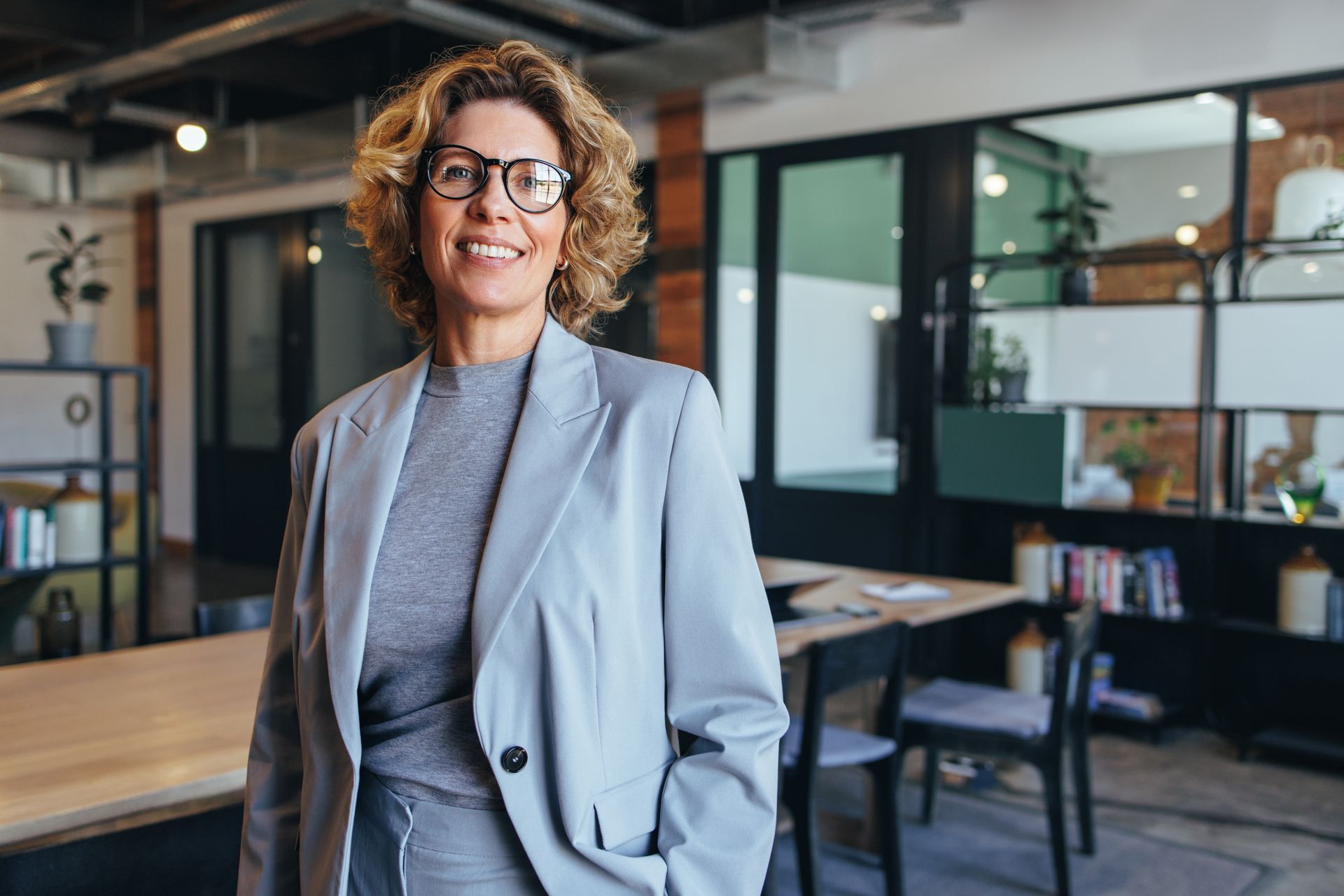 a woman wearing glasses and a suit is the director for a large company needing liability insurance
