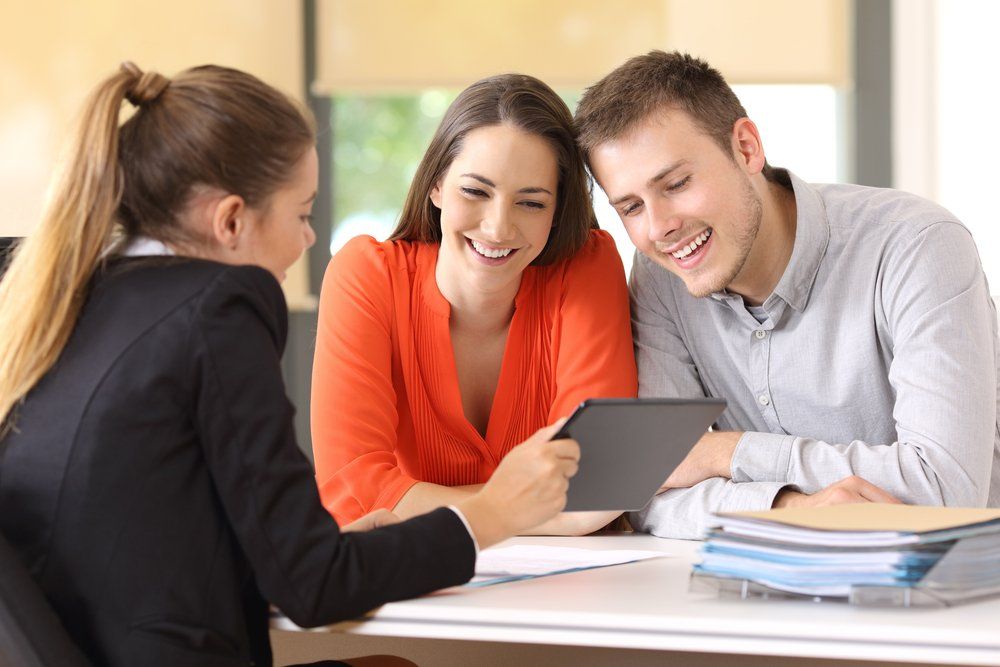 Young couple looking at tablet talking with a general liability insurance advisor