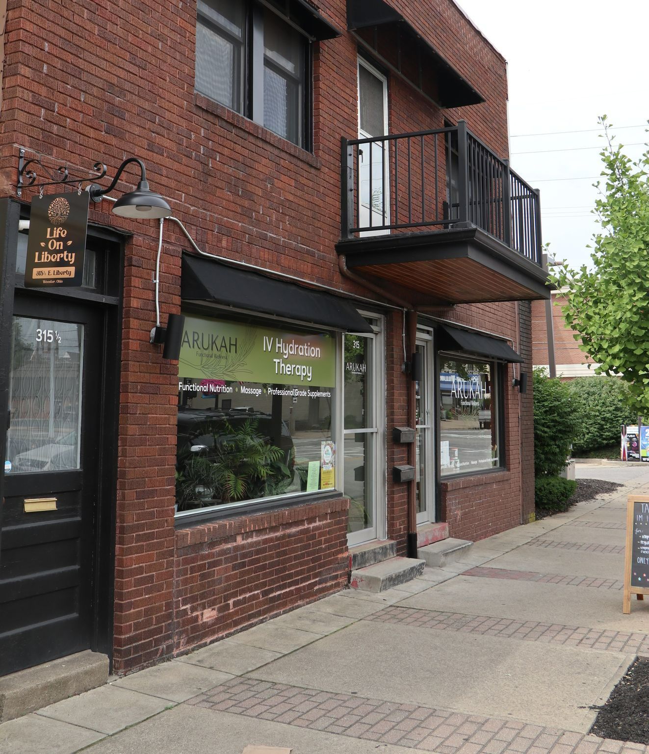 Brick building with shops, awning, and balcony. 