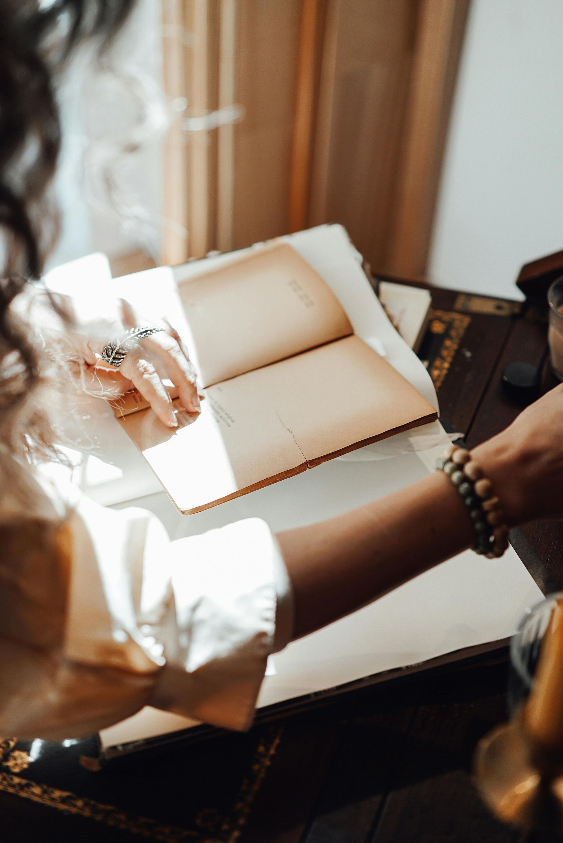 Woman journaling with gratitude and sunlight streaming in — symbolizing thankfulness, generosity, and holistic healing at Arukah Functional Wellness.
