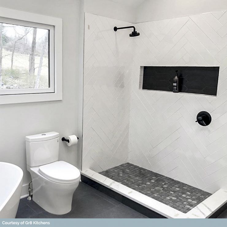 Bright modern bathroom with a walk-in shower, toilet, and window.