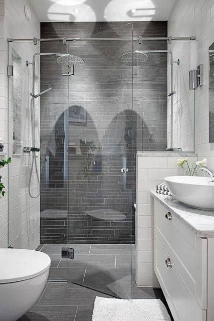 Modern bathroom with glass-enclosed shower, white vanity, and wall-mounted toilet