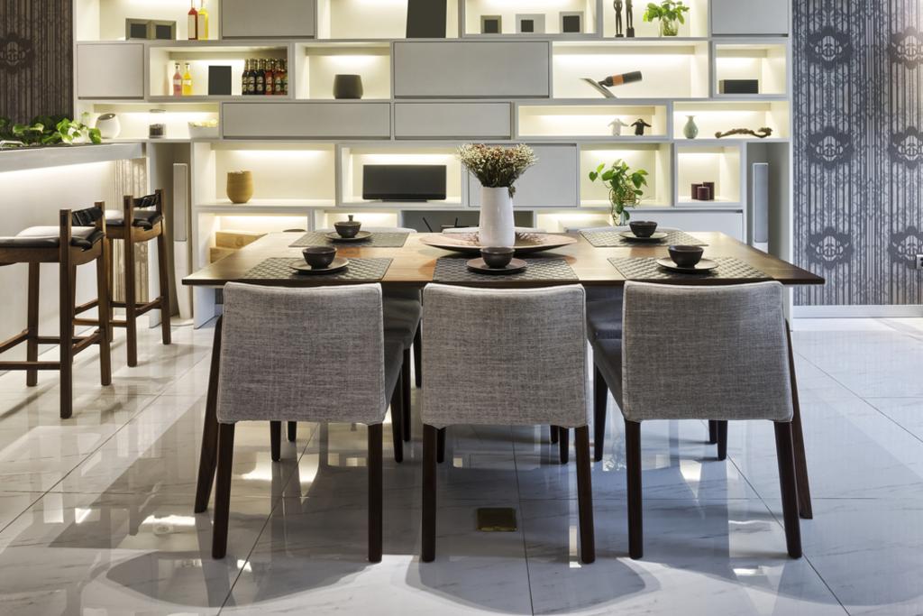 Modern dining room with a set table, upholstered chairs, and built-in shelves in warm neutral tones