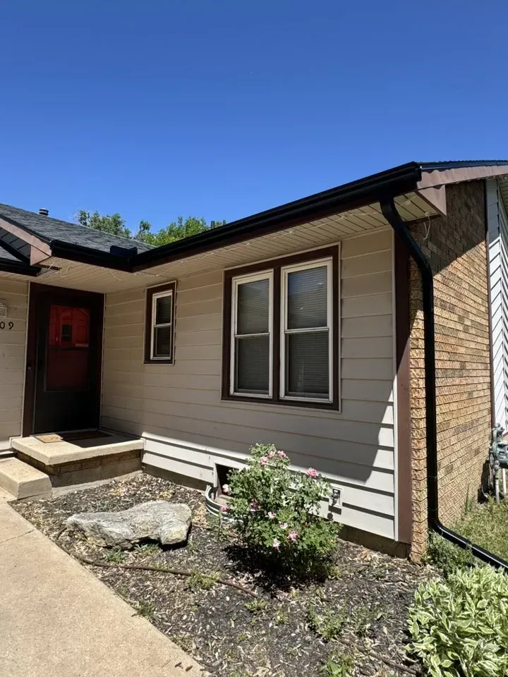 side of house with brown gutters on a newly installed fascia
