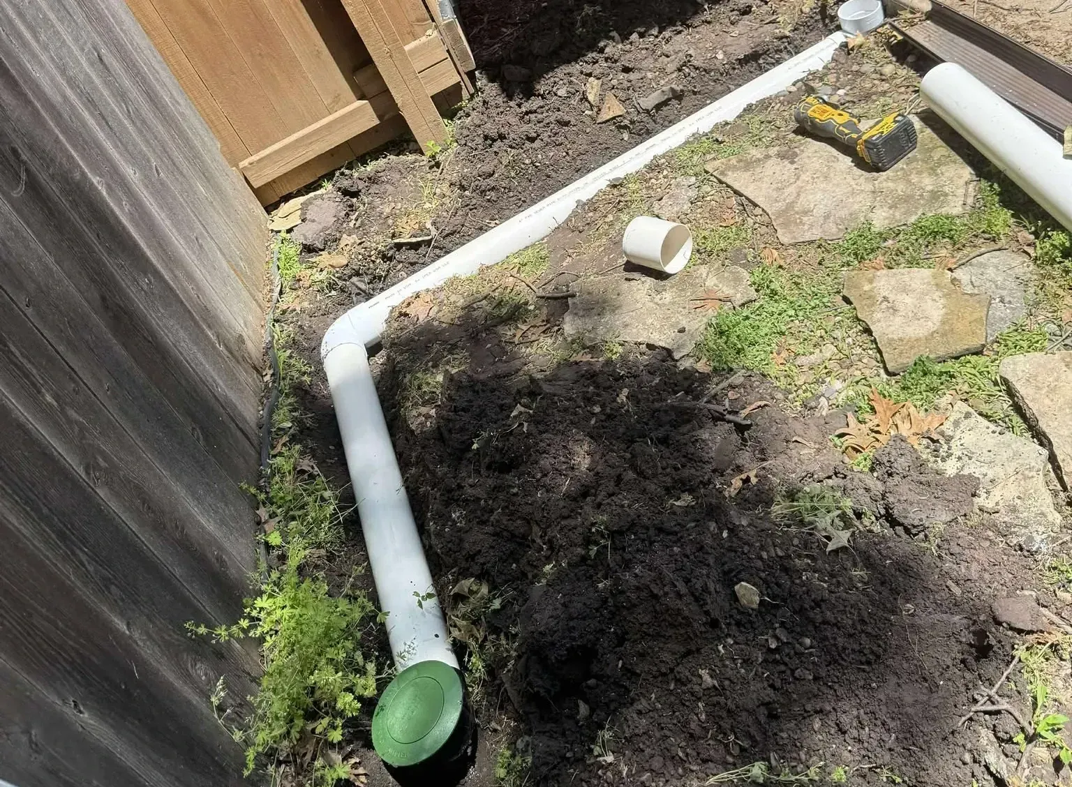French drain through yard into the ground along a fence