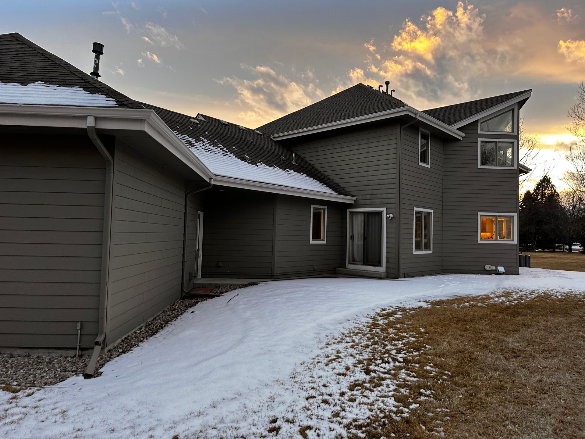 A large house with snow on the ground in front of it