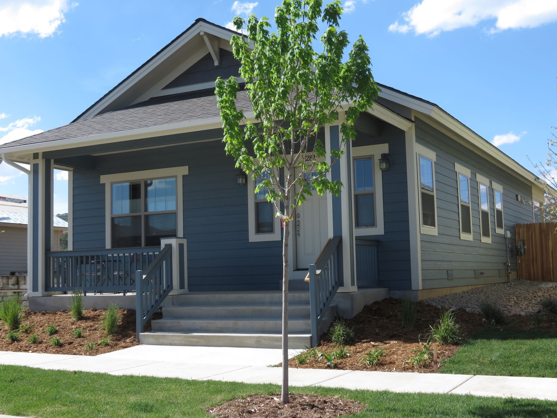 A blue house with a tree in front of it