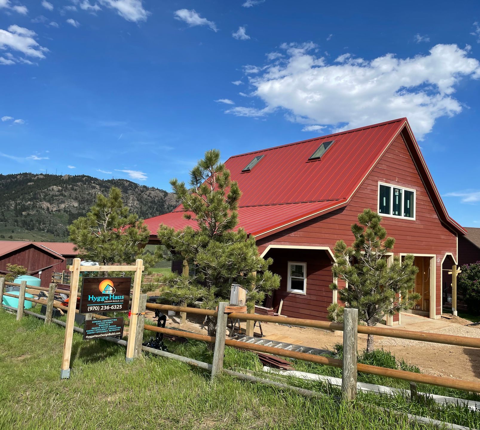 A red barn with a wooden fence in front of it