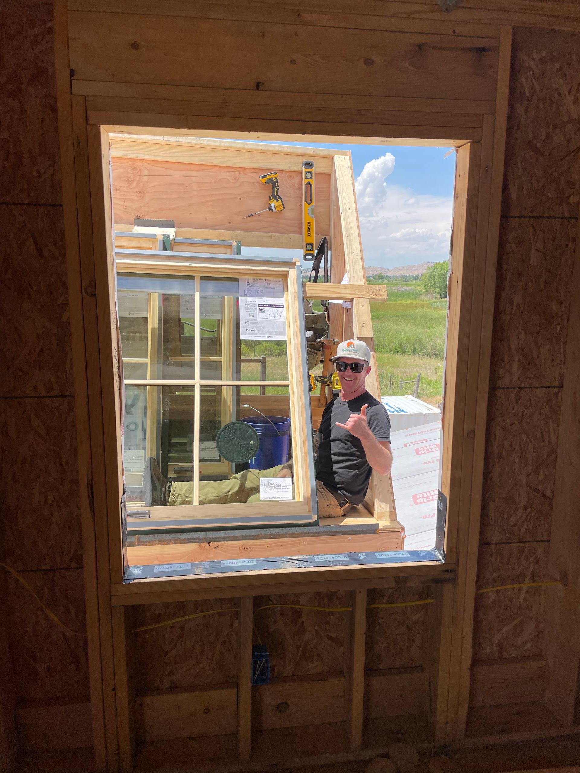 A man is standing in front of a window in a building under construction.