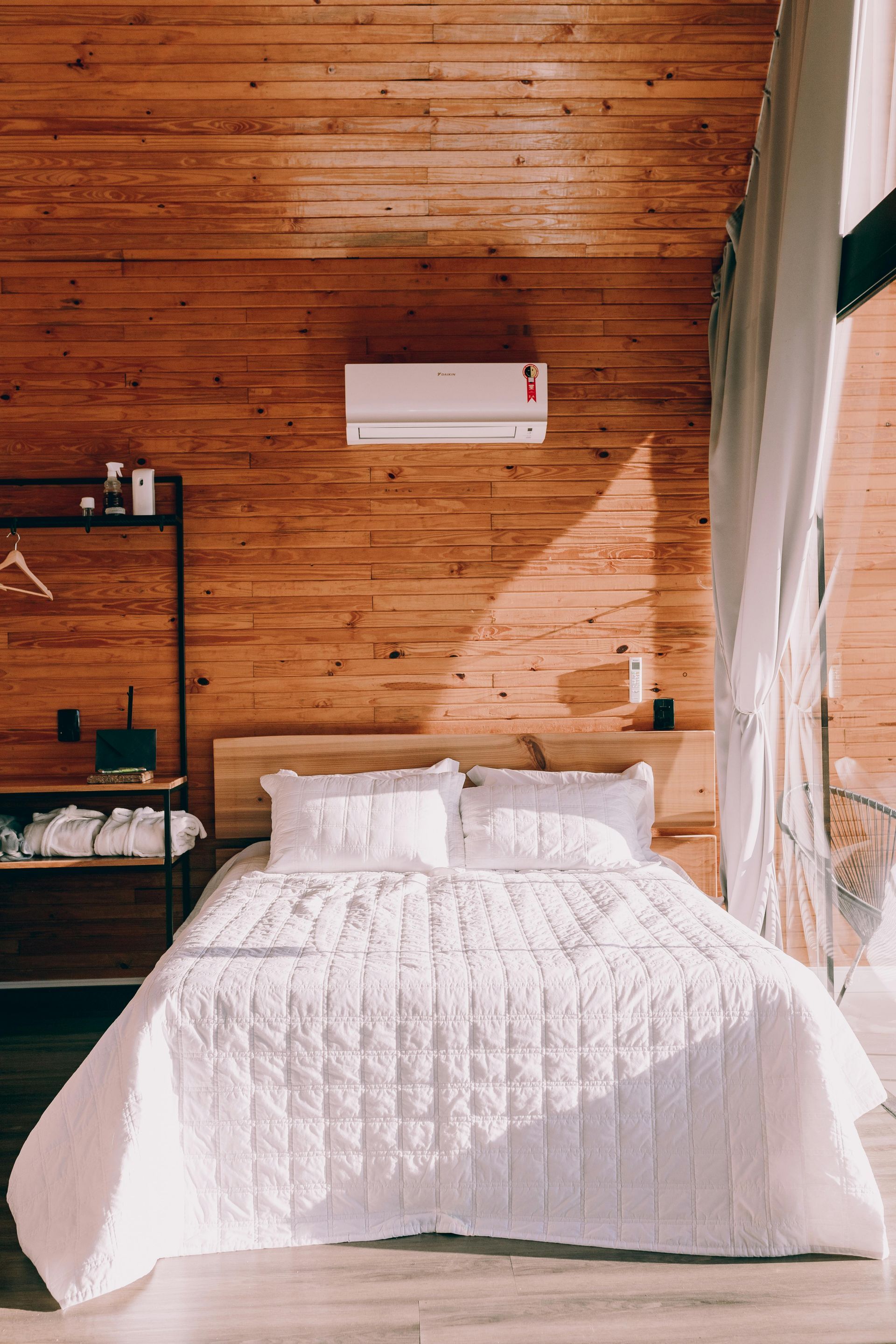 A bedroom with a bed and a wooden wall.
