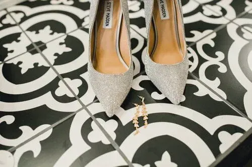 Silver pointed-toe heels on a black-and-white patterned tile floor