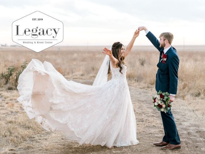Bride and groom dancing in a field, bride’s long white dress flowing in the wind