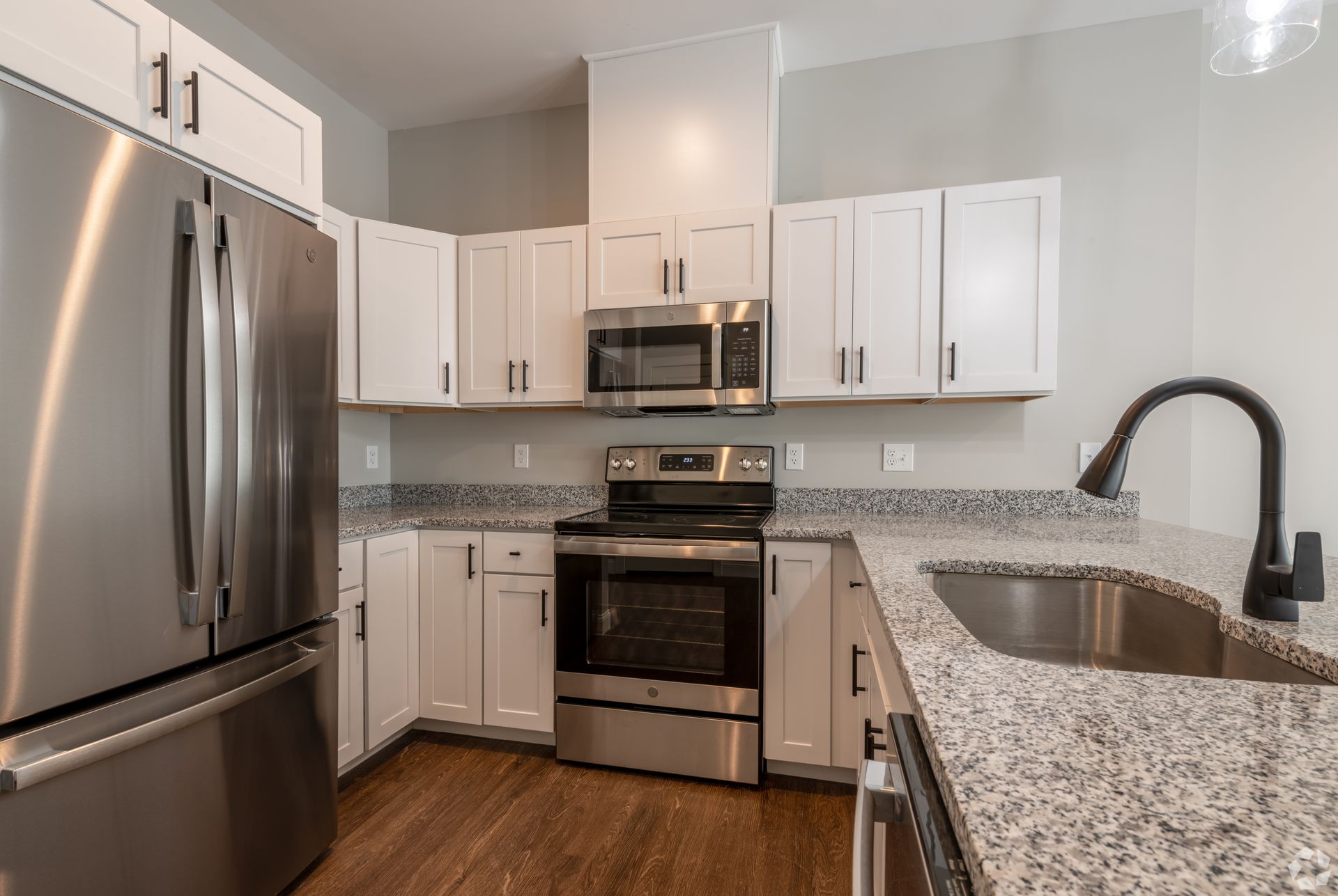 A new kitchen with granite countertops and stainless-steel GE appliances at The Kiln