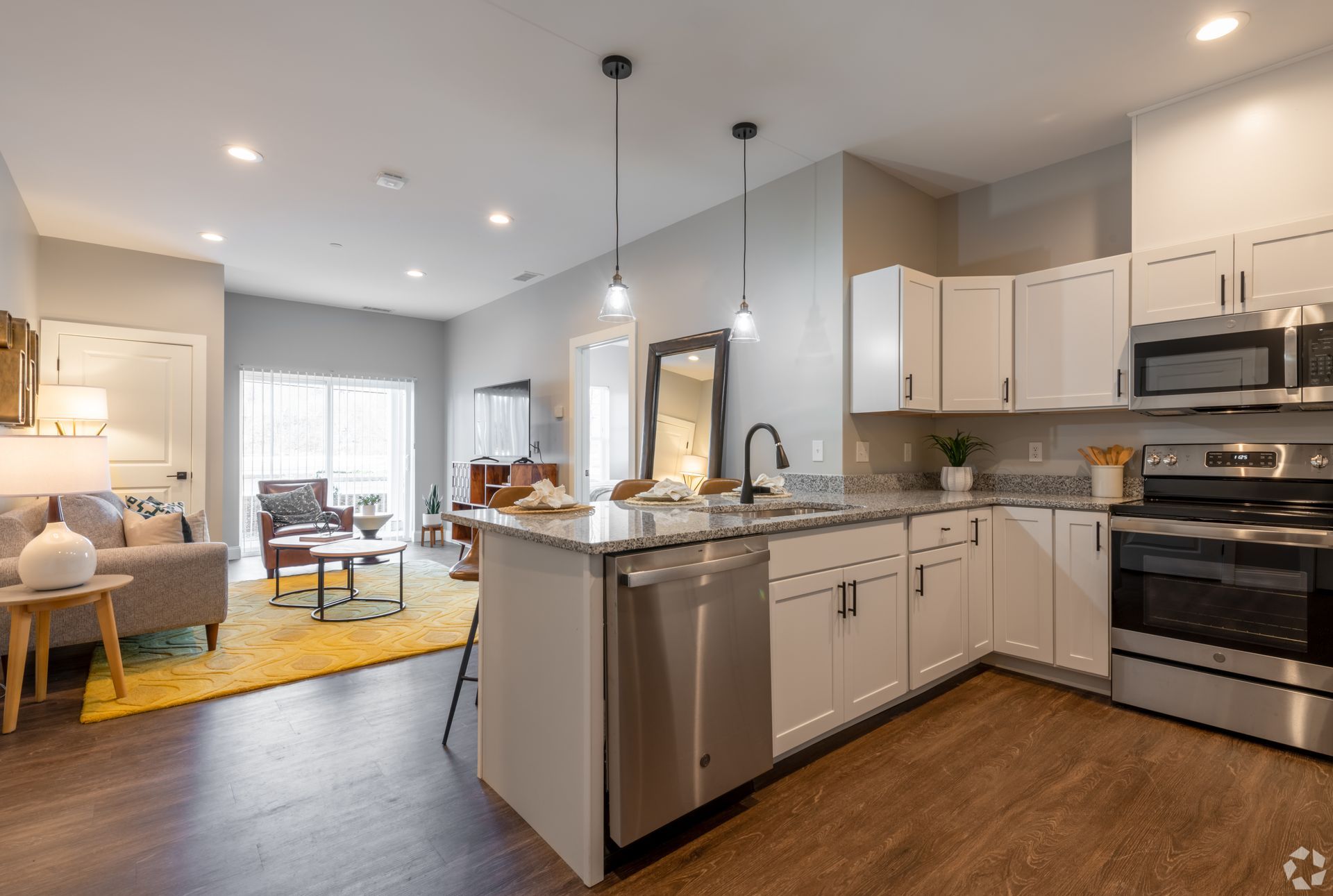 A modern luxury kitchen with granite counters and stainless-steel appliances at The Kiln in Worcester, MA
