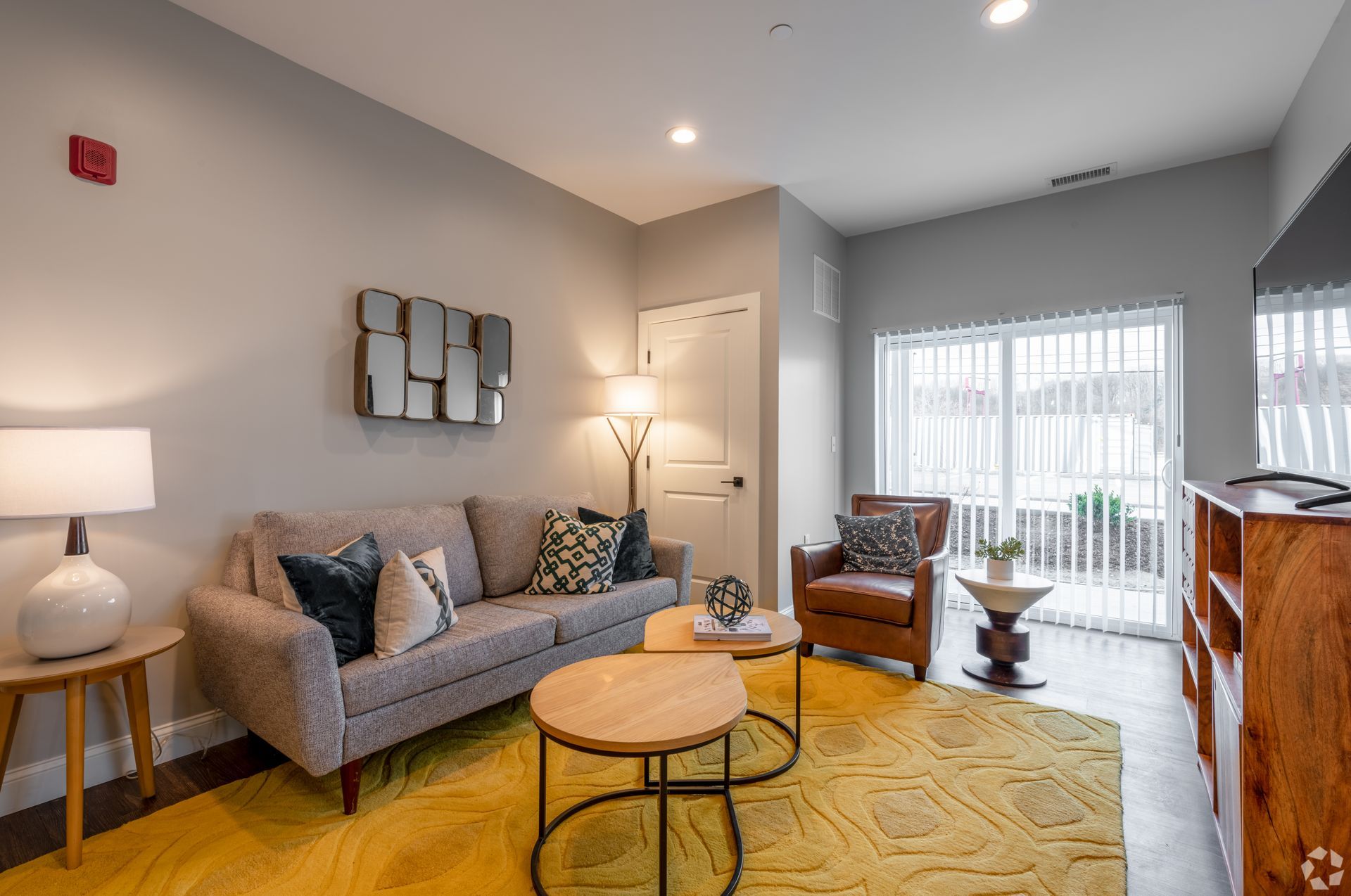 a living room with a couch , chair , coffee table and television .