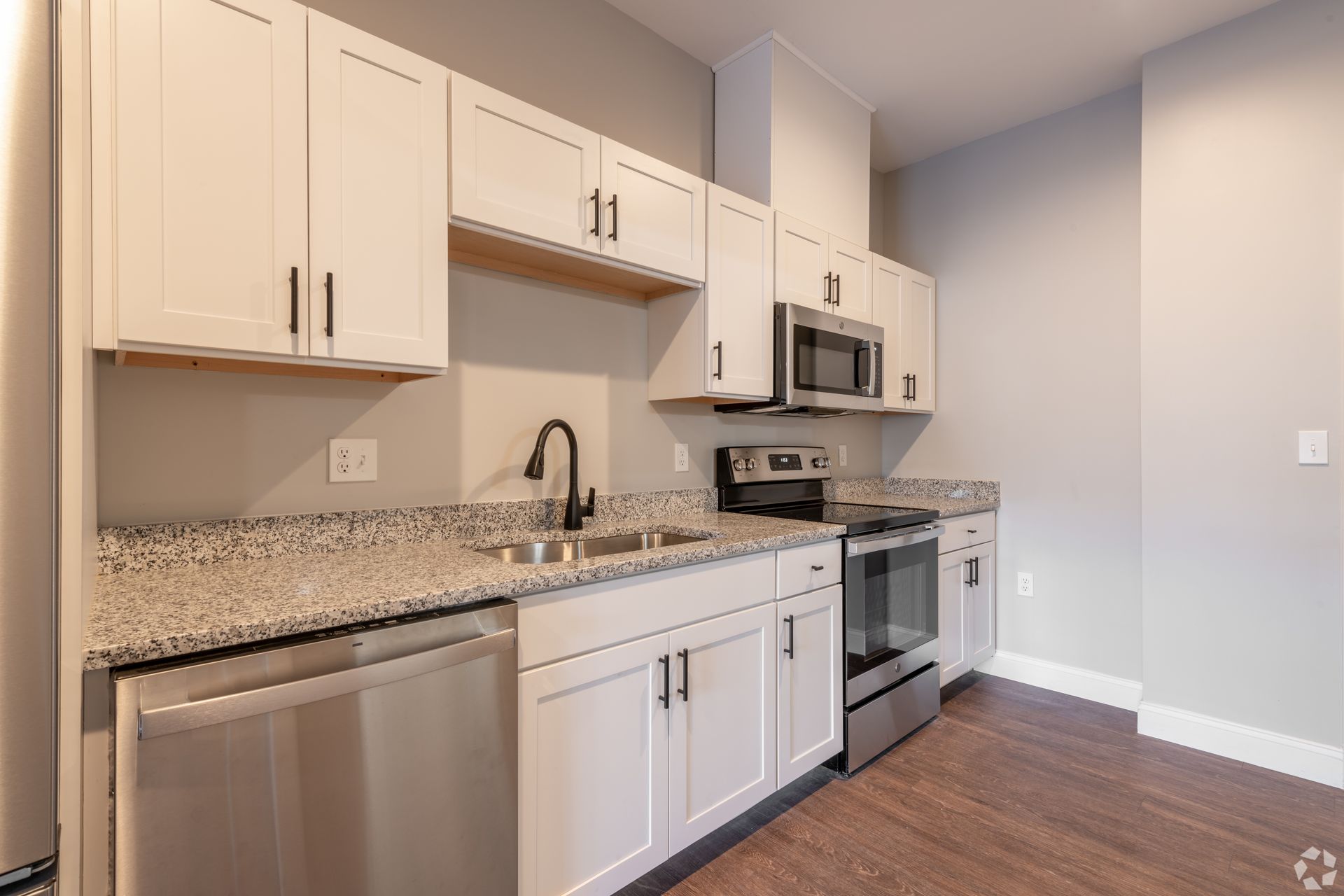 a kitchen with stainless steel appliances and white cabinets .