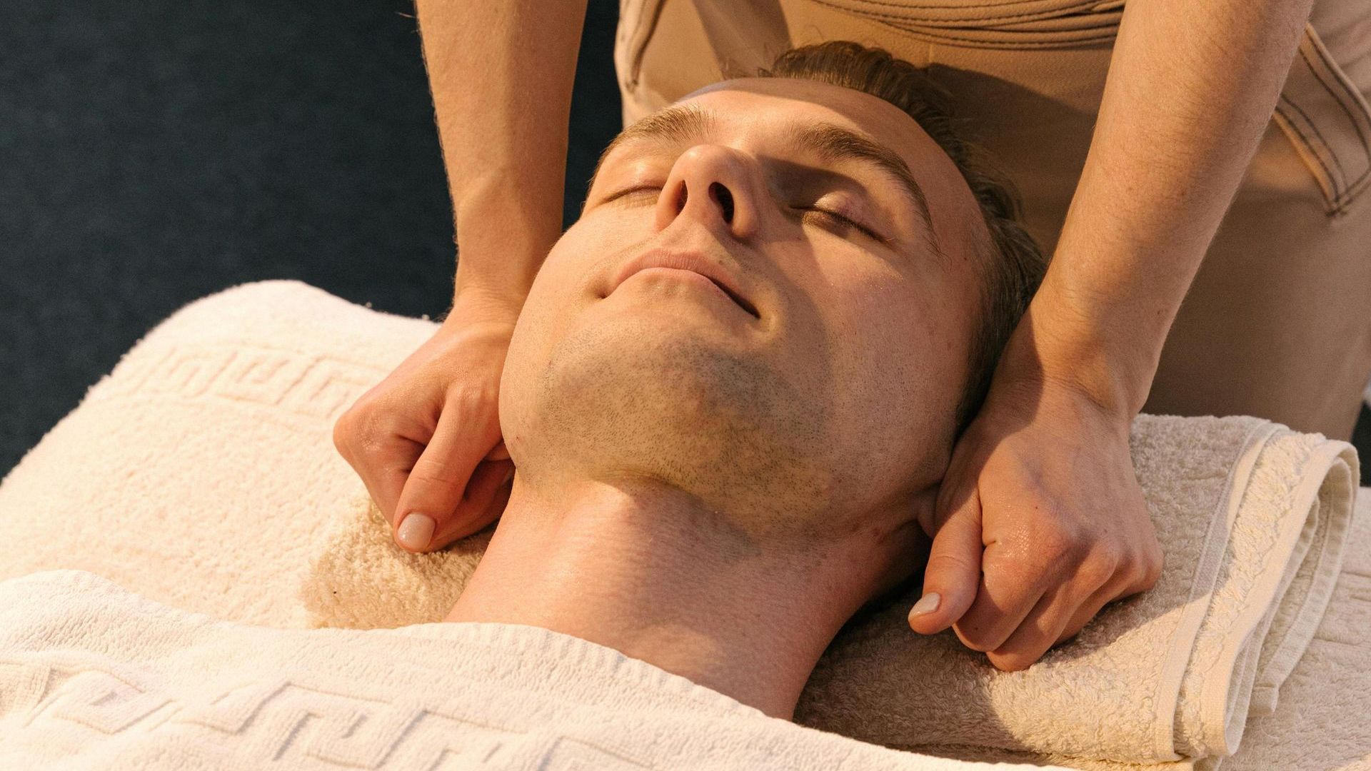 A man is laying on a table getting a massage from a woman.