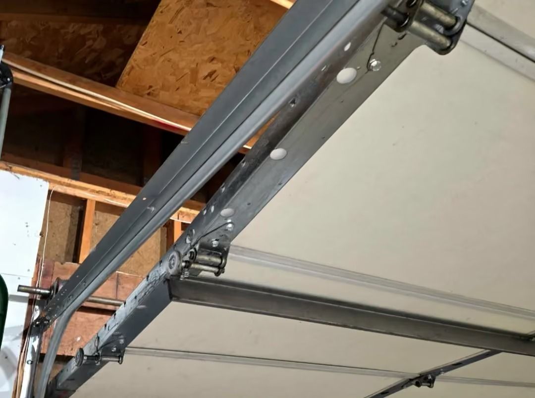 Garage ceiling with overhead garage door tracks and a partially open door mechanism