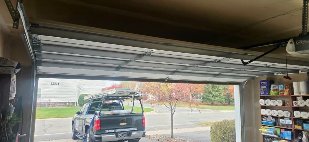 Black SUV in a garage, viewed from inside near the open overhead door.