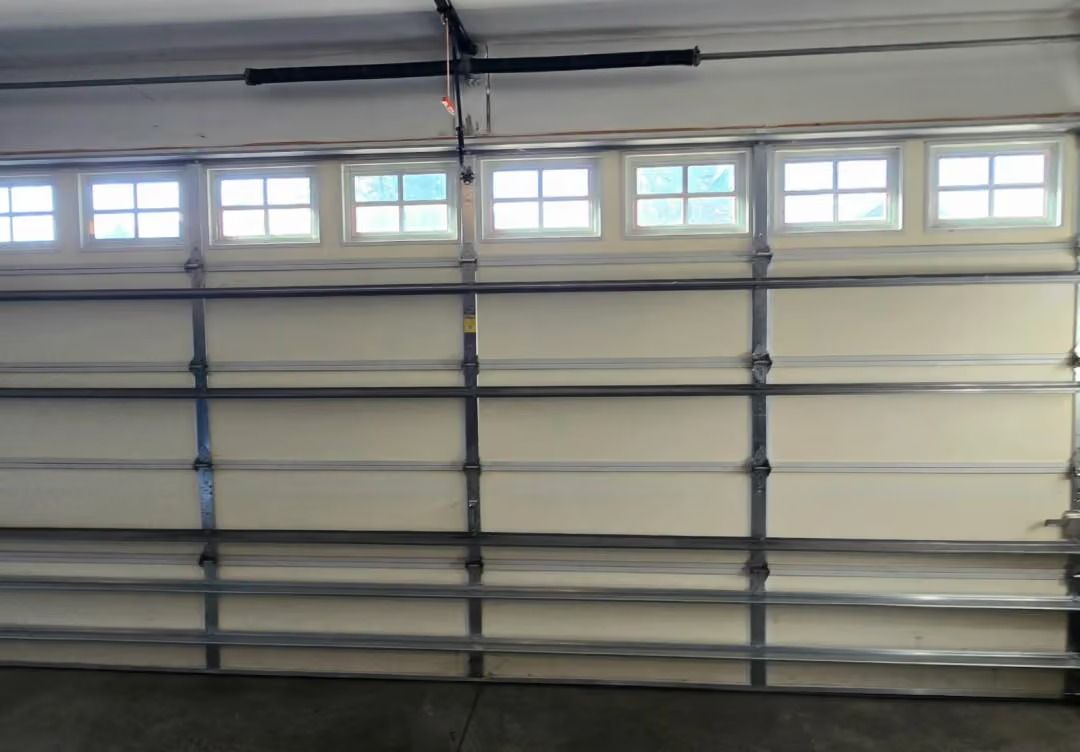 Closed white garage door with small windows along the top row