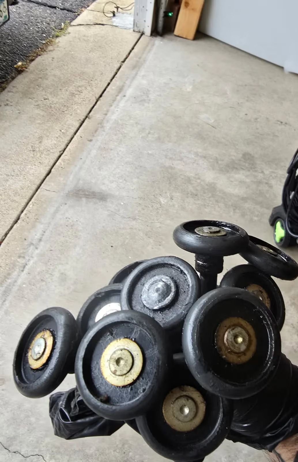 A stroller wheel assembly resting on a concrete floor near a garage door