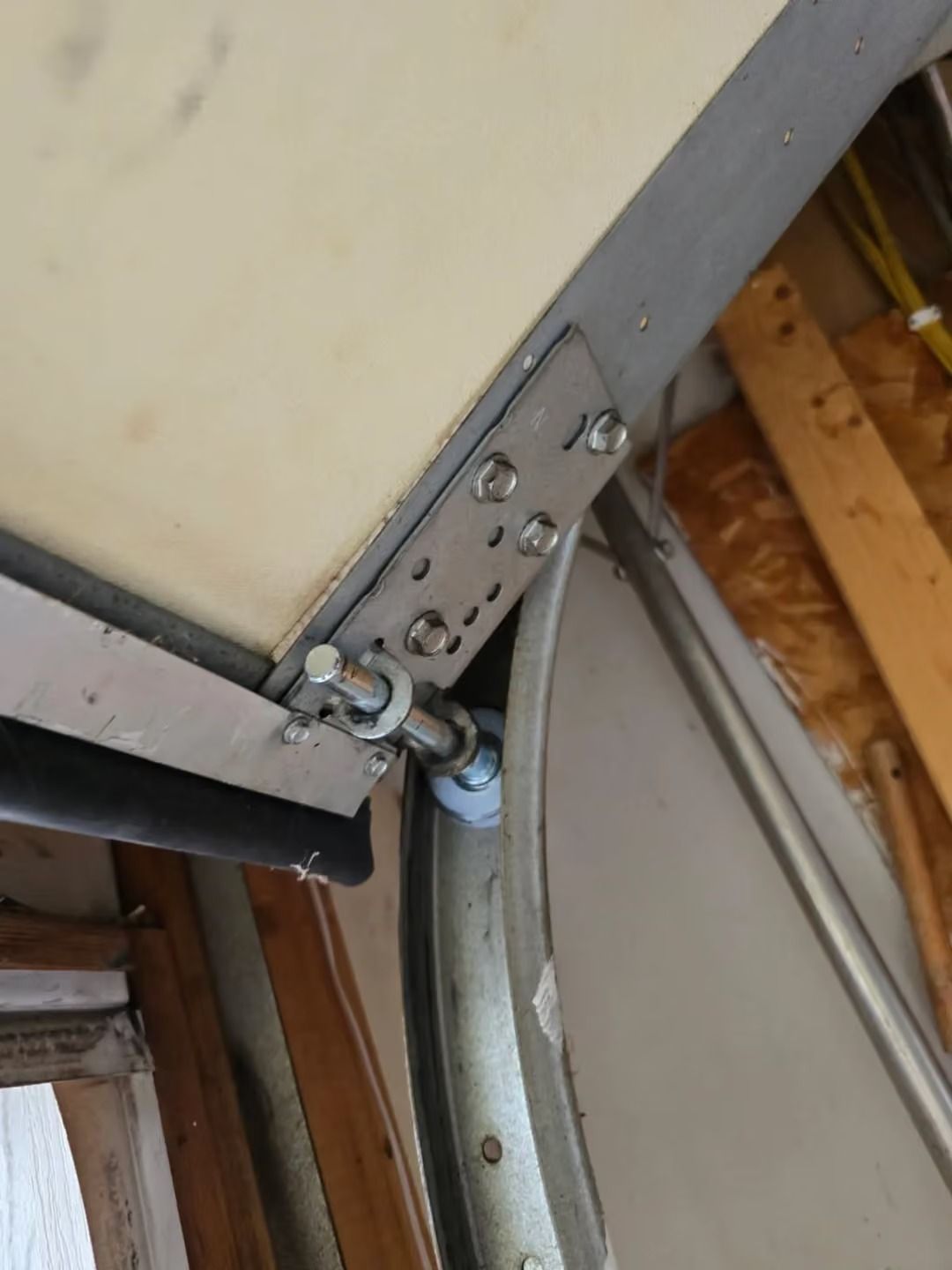 Close-up of a metal hinge and roller bracket on a garage door track