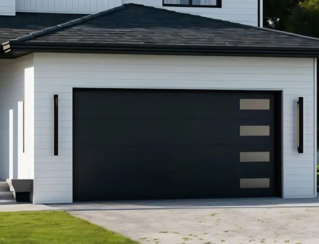 Modern white house with a black garage door and driveway in front