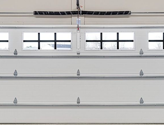 White garage door with four small windows along the top and horizontal panels.