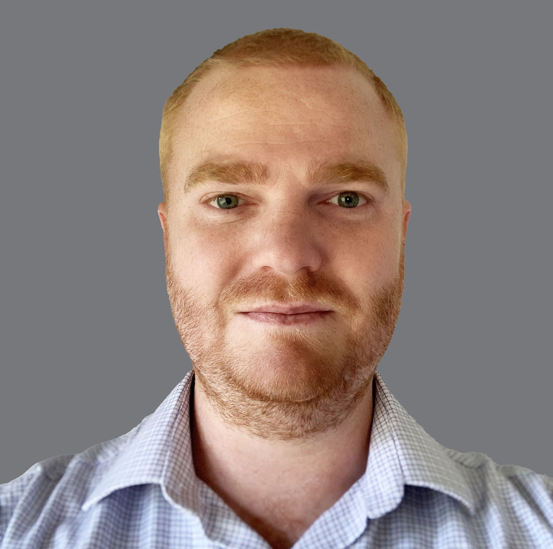 A man with a beard is wearing a blue shirt and looking at the camera.