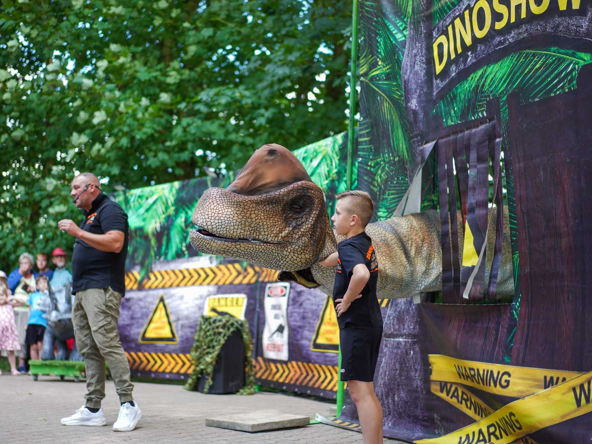 Junge mit Dinosaurierpuppe auf der Bühne