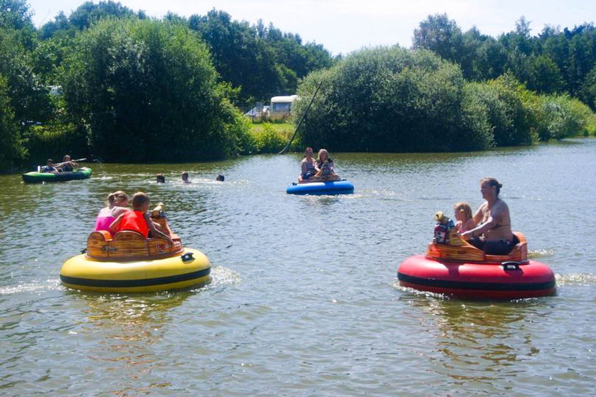 Menschen fahren mit aufblasbaren Bumper Boats auf einem See