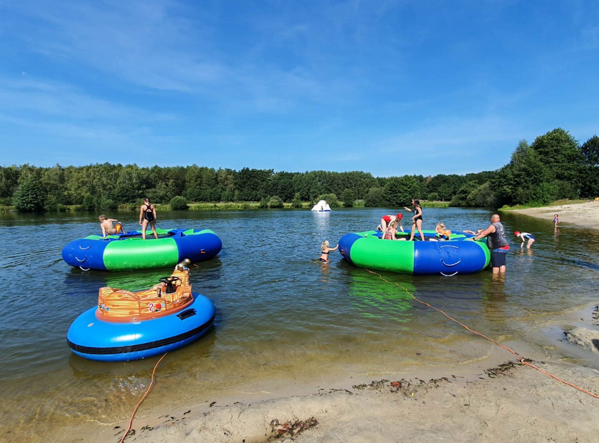 Menschen, die auf Wasserspielzeugen in einem See spielen.