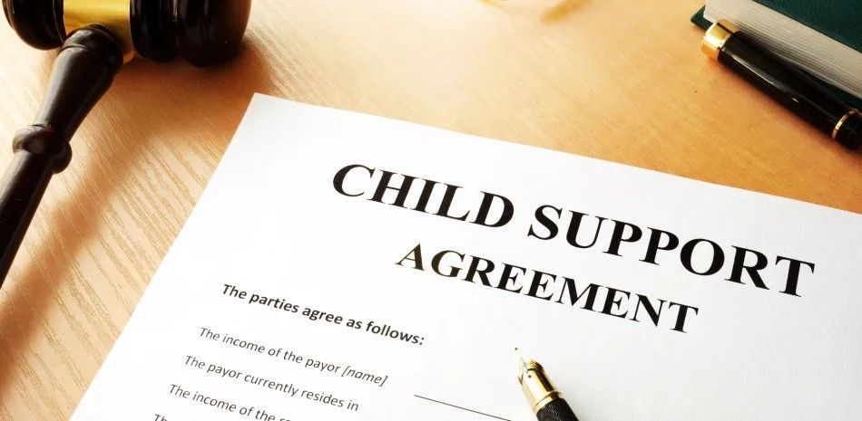 Child support agreement document on a desk with a pen and glasses nearby