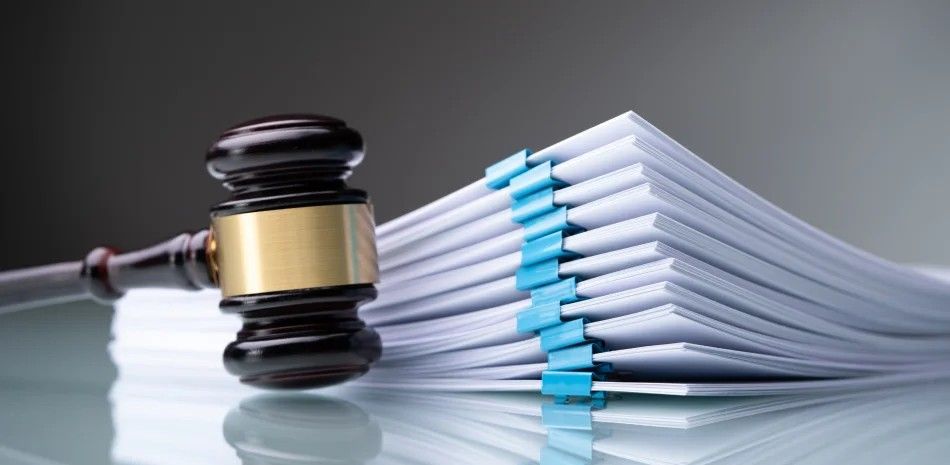 Judge’s gavel beside a stack of papers, symbolizing legal documents or a court ruling