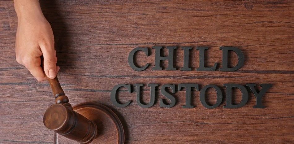 Wooden judge’s gavel beside the words “CHILD CUSTODY” on a desk