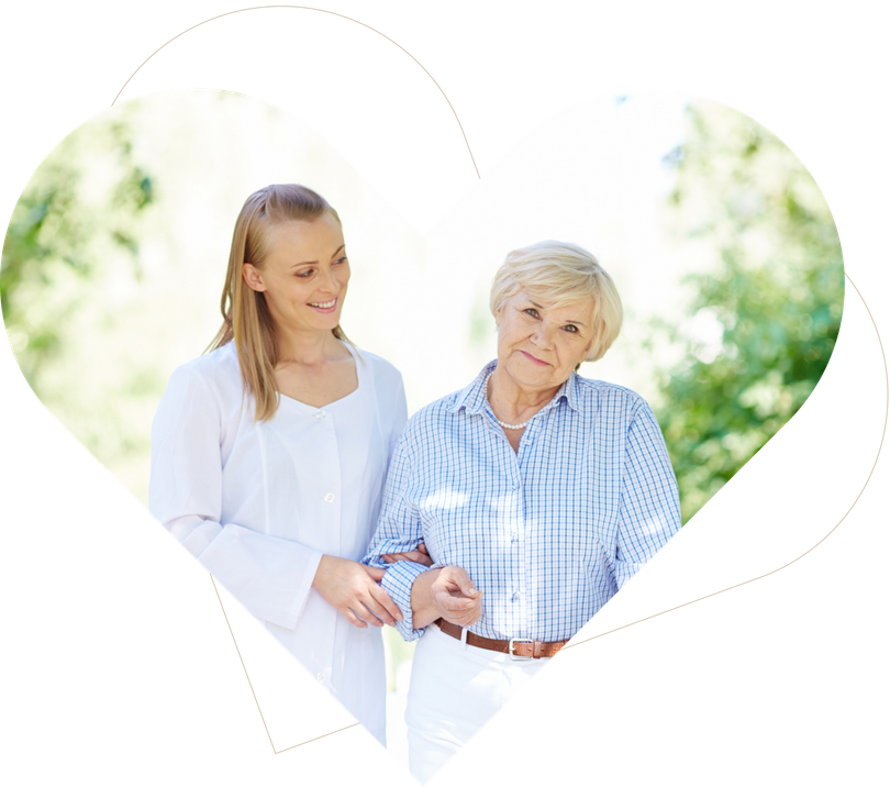 Two women standing together outdoors inside a heart shape, smiling and holding hands
