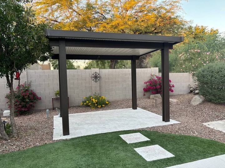 Modern backyard pergola on white patio with desert landscaping and stepping stones